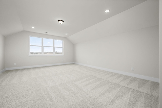 additional living space with vaulted ceiling and light colored carpet