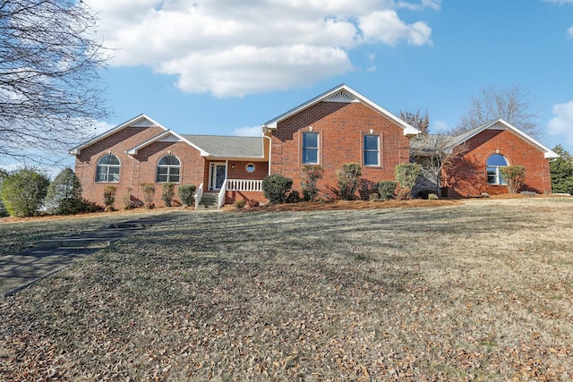 ranch-style house featuring a front lawn and covered porch