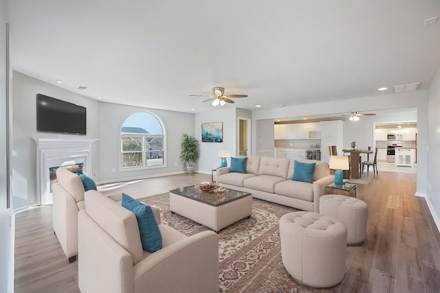 living room with ceiling fan and light hardwood / wood-style floors