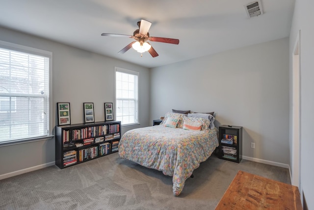 carpeted bedroom with a ceiling fan, visible vents, and baseboards