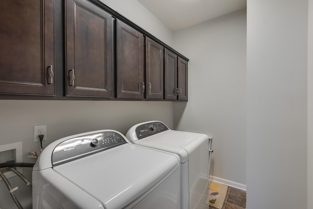 washroom with washing machine and clothes dryer, cabinet space, and baseboards