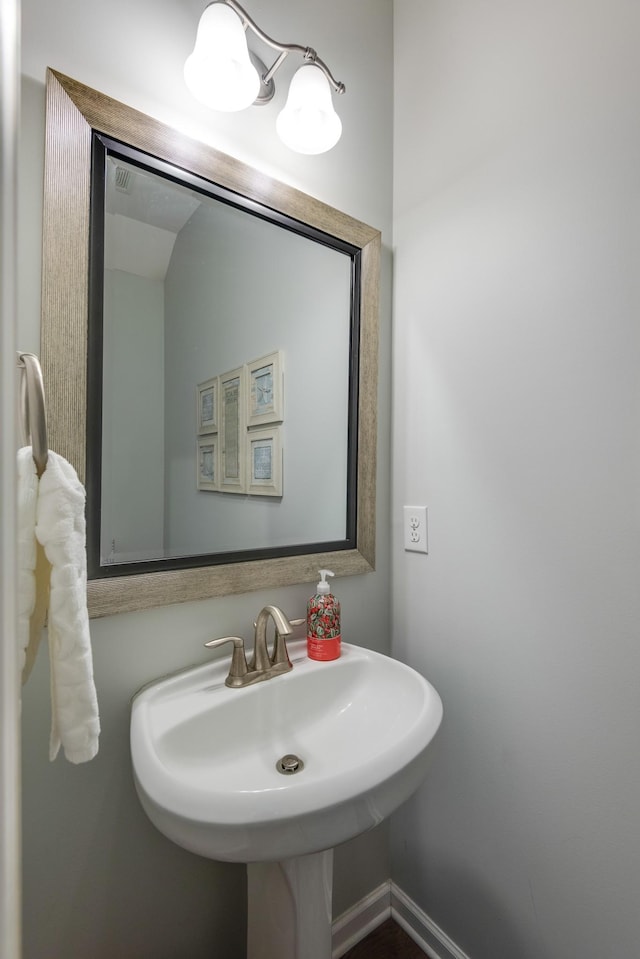 bathroom with a sink and baseboards