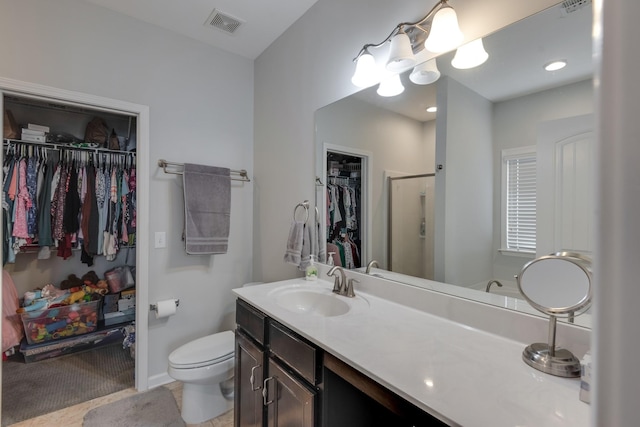 bathroom with a stall shower, visible vents, toilet, a spacious closet, and vanity