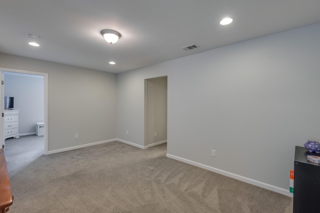 spare room with light carpet, recessed lighting, visible vents, and baseboards