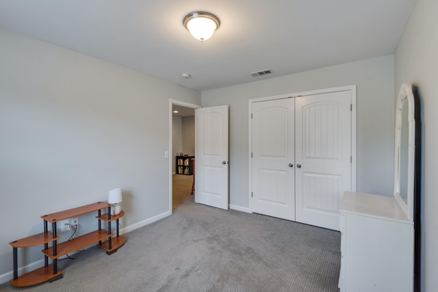 carpeted bedroom with a closet, visible vents, and baseboards