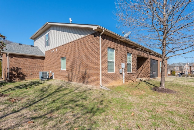 view of side of home featuring brick siding and a lawn