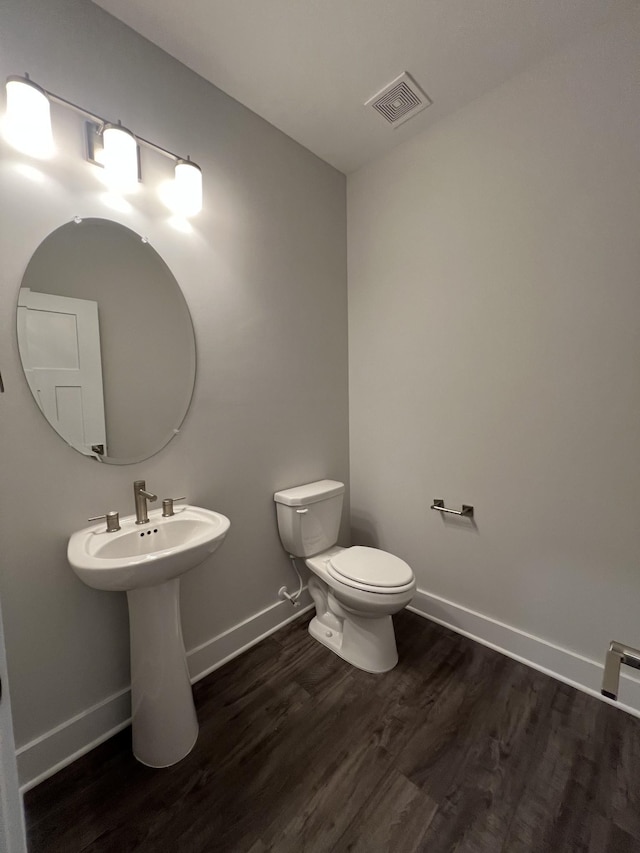 bathroom with hardwood / wood-style flooring and toilet