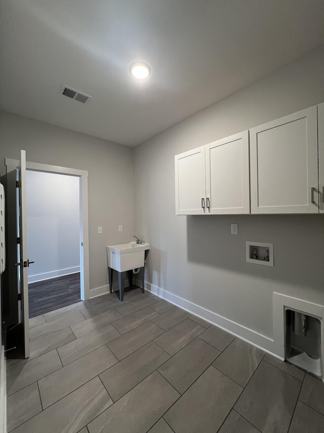 washroom with sink, hookup for a washing machine, and cabinets