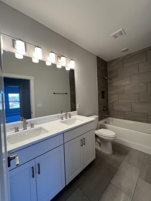 full bathroom with vanity, tiled shower / bath combo, and toilet