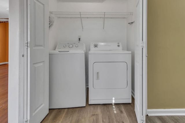 laundry room featuring separate washer and dryer and hardwood / wood-style flooring