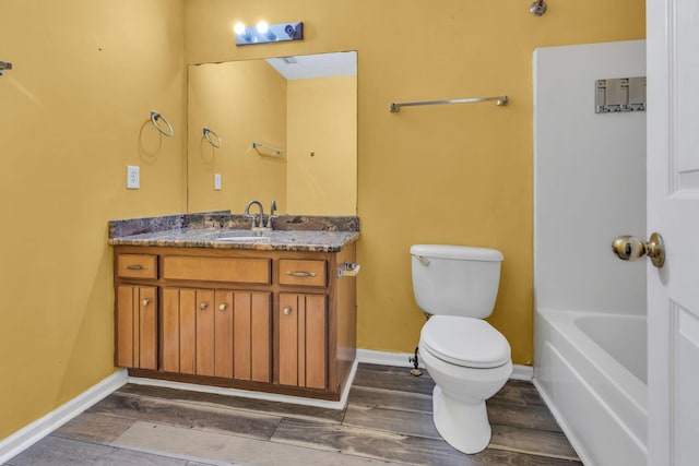 bathroom featuring vanity, a bath, and toilet