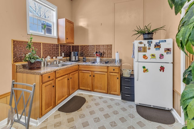 kitchen featuring light tile patterned flooring, sink, gas stovetop, tasteful backsplash, and white refrigerator