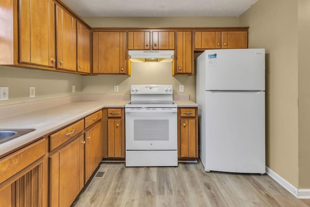 kitchen with white appliances and light hardwood / wood-style floors