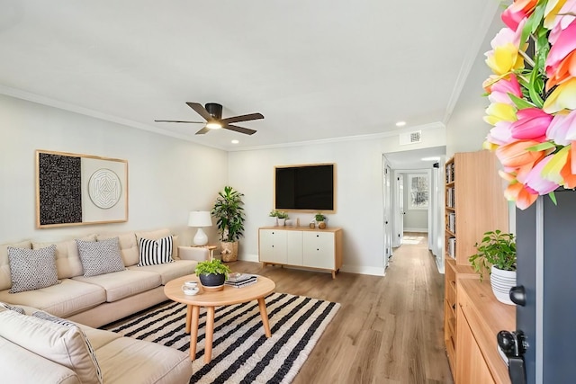 living room featuring crown molding, ceiling fan, and light hardwood / wood-style floors