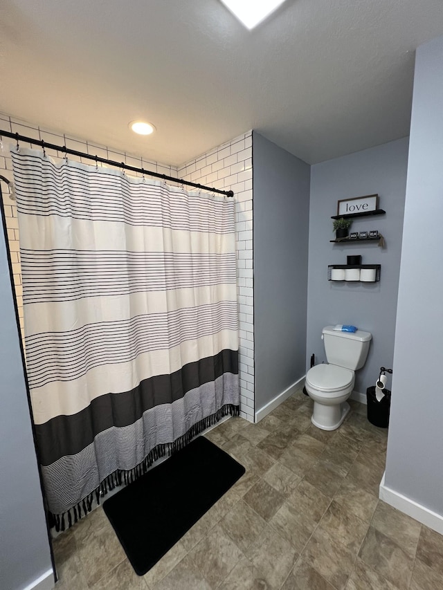 bathroom with toilet and a shower with shower curtain