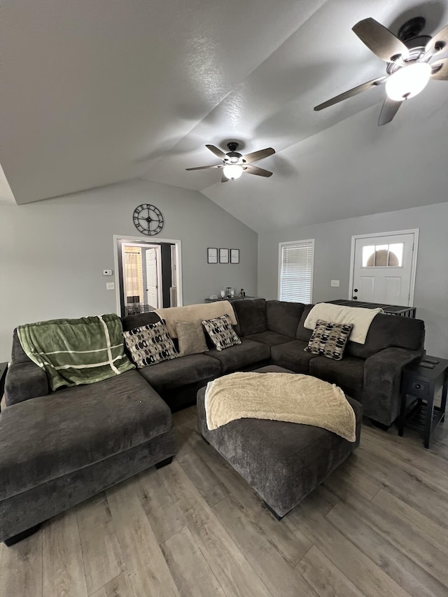 living room featuring vaulted ceiling, ceiling fan, and light wood-type flooring