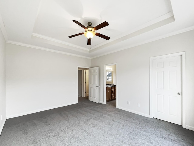 unfurnished bedroom with a raised ceiling, ensuite bathroom, crown molding, and ceiling fan