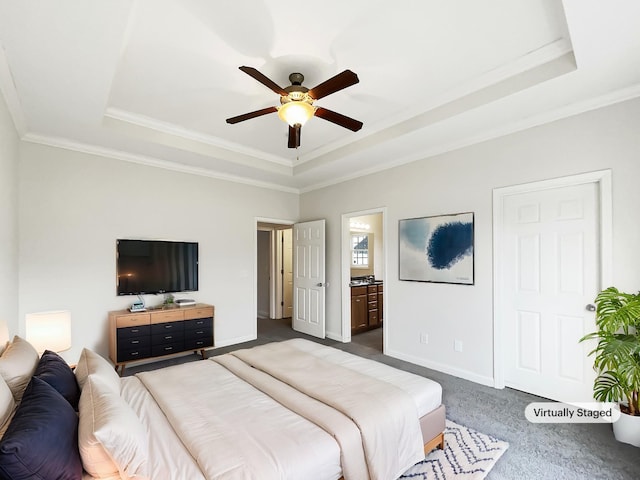 bedroom featuring ceiling fan, ensuite bathroom, and a raised ceiling