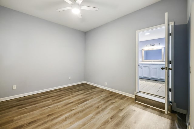 spare room with sink, hardwood / wood-style flooring, and ceiling fan