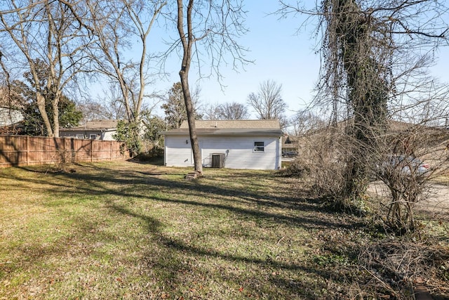 back of house with central AC and a yard