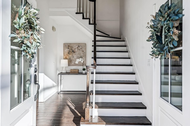 staircase with wood-type flooring and plenty of natural light