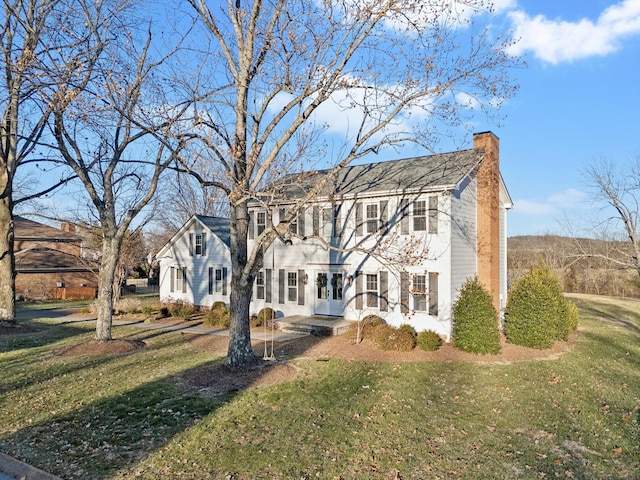 colonial house featuring a front yard and french doors