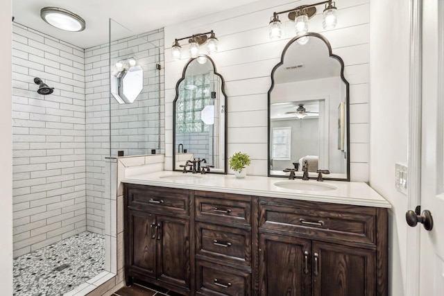 bathroom featuring tiled shower and vanity