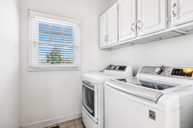 laundry area with cabinets, separate washer and dryer, and light tile patterned floors