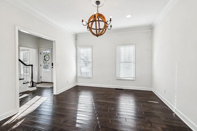 spare room featuring dark wood-type flooring, crown molding, and a notable chandelier