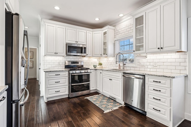 kitchen with dark wood-type flooring, appliances with stainless steel finishes, sink, and white cabinets