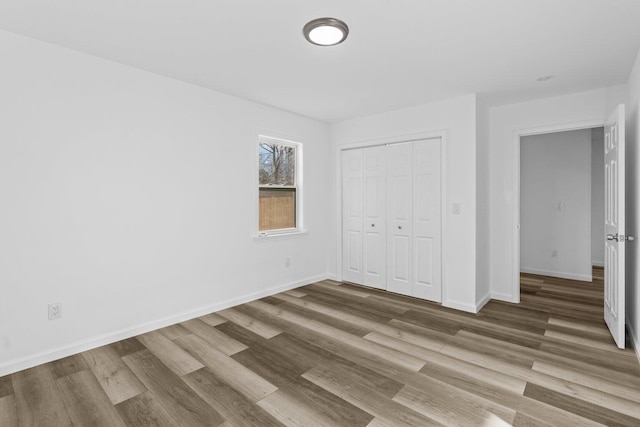 unfurnished bedroom featuring hardwood / wood-style flooring and a closet