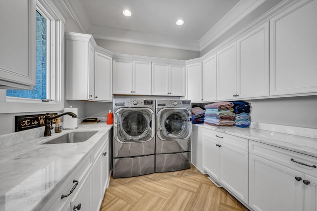 washroom featuring crown molding, cabinets, sink, and washing machine and dryer