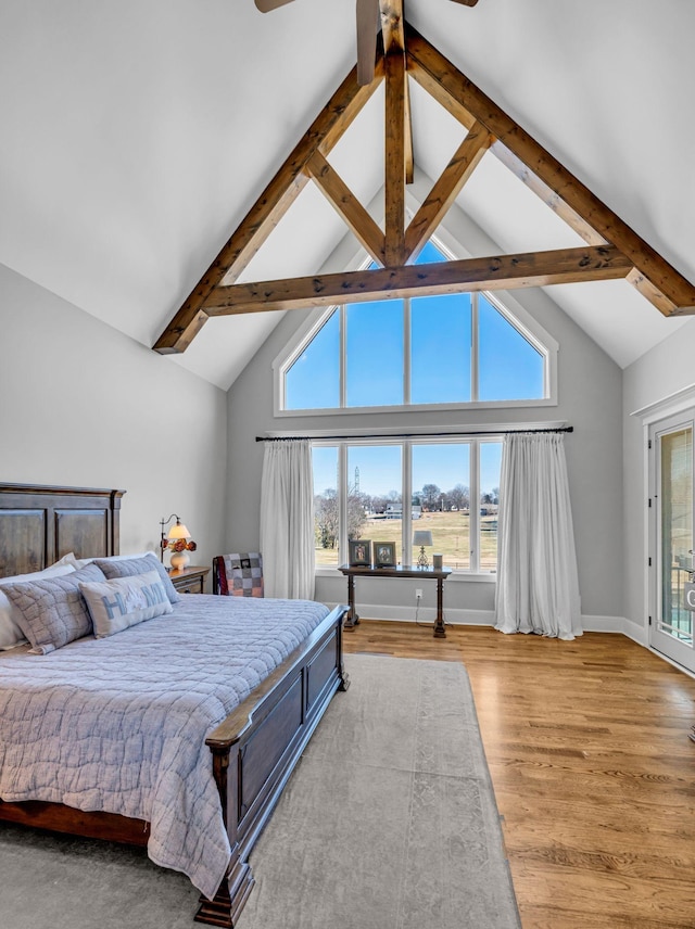 bedroom with lofted ceiling with beams, ceiling fan, and light hardwood / wood-style floors