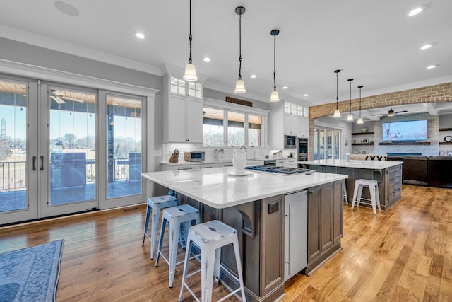 kitchen featuring white cabinetry, a large island, pendant lighting, and backsplash