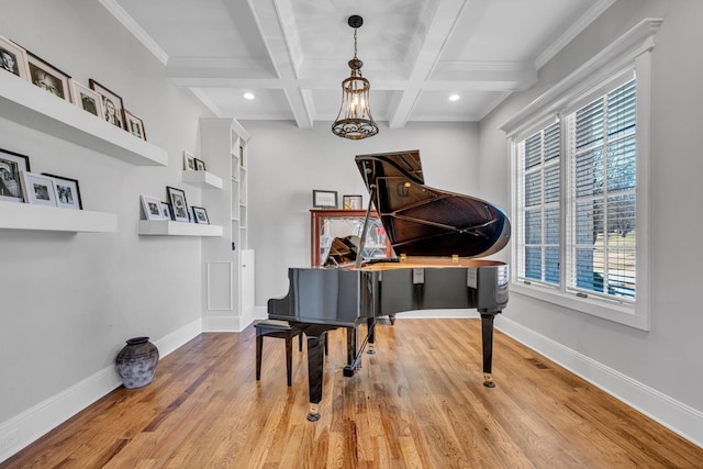 miscellaneous room featuring beamed ceiling, coffered ceiling, an inviting chandelier, and hardwood / wood-style flooring