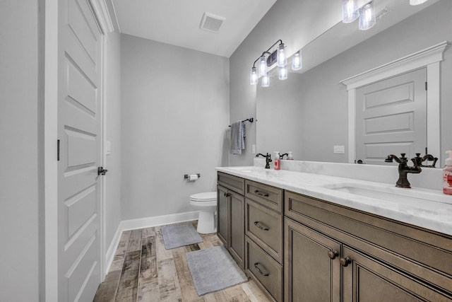 bathroom featuring wood-type flooring, toilet, and vanity