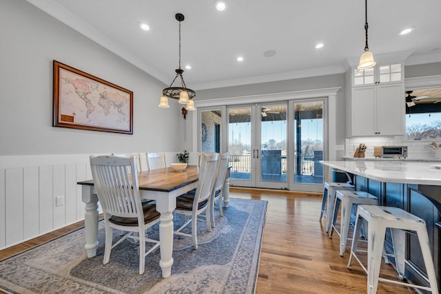 dining space featuring crown molding, french doors, and light wood-type flooring