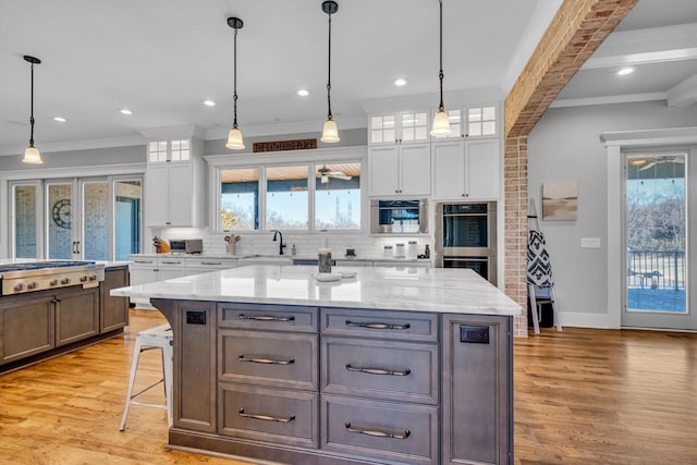 kitchen featuring tasteful backsplash, pendant lighting, a kitchen island, and white cabinets