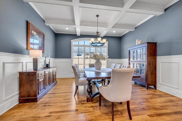 dining space featuring beamed ceiling, coffered ceiling, an inviting chandelier, and light hardwood / wood-style floors