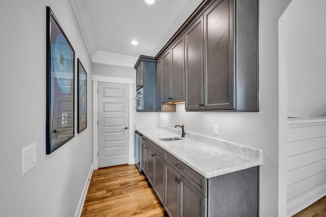 kitchen featuring ornamental molding, dark brown cabinets, and sink