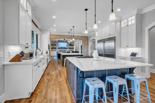 kitchen with stainless steel appliances, hanging light fixtures, and decorative backsplash