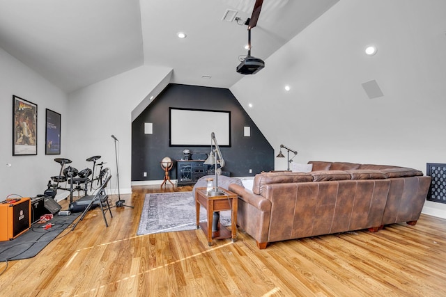 cinema room featuring lofted ceiling and light wood-type flooring