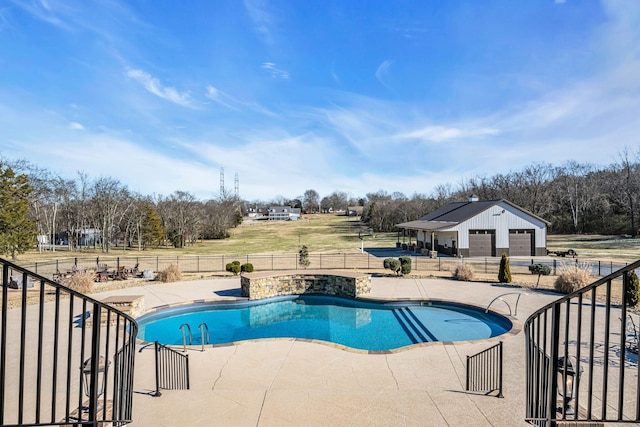 view of swimming pool featuring an outbuilding, a garage, and a patio area