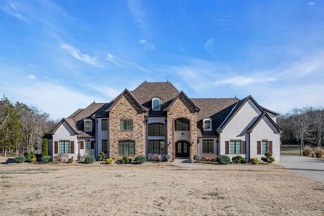 french country inspired facade featuring a front lawn