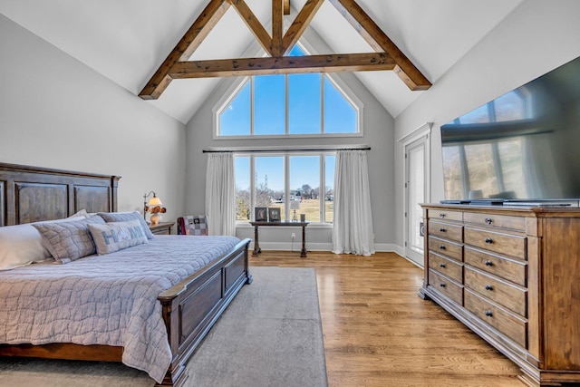 bedroom with beamed ceiling, high vaulted ceiling, and light wood-type flooring