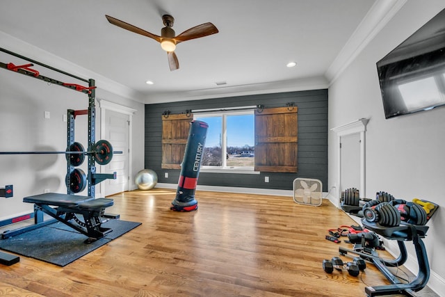 exercise area with ceiling fan, ornamental molding, and wood-type flooring