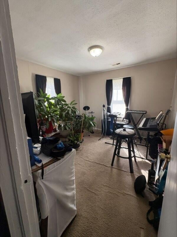 carpeted office space with a textured ceiling