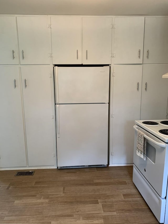 kitchen with hardwood / wood-style flooring, white cabinetry, and white appliances