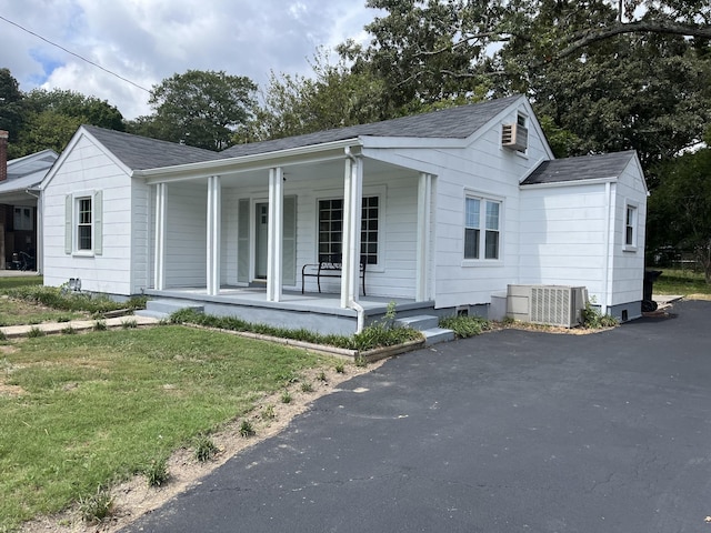 view of front of home with a porch, central AC unit, and a front lawn