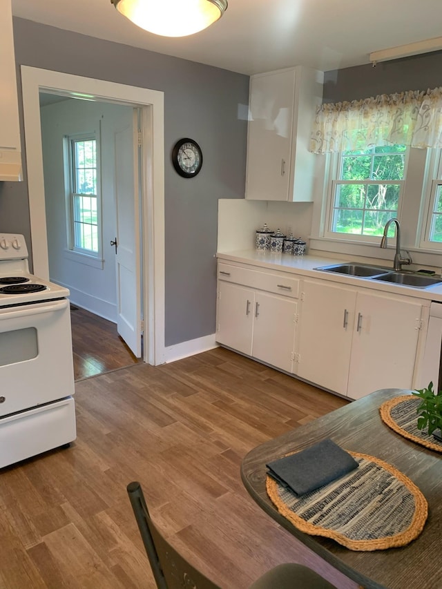 kitchen with sink, hardwood / wood-style floors, extractor fan, white cabinets, and white electric stove